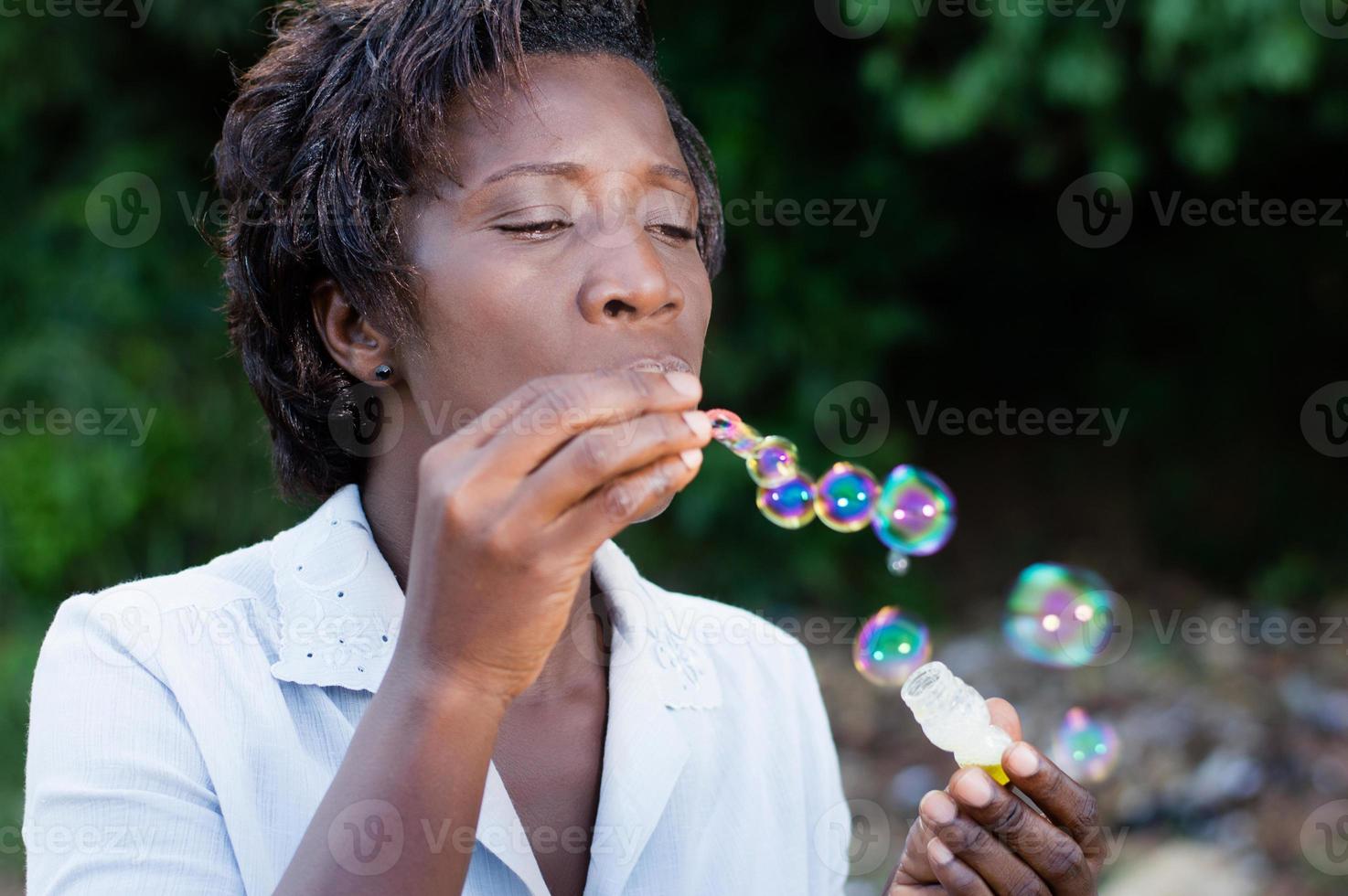 ganska ung kvinna som blåser bubblor. foto