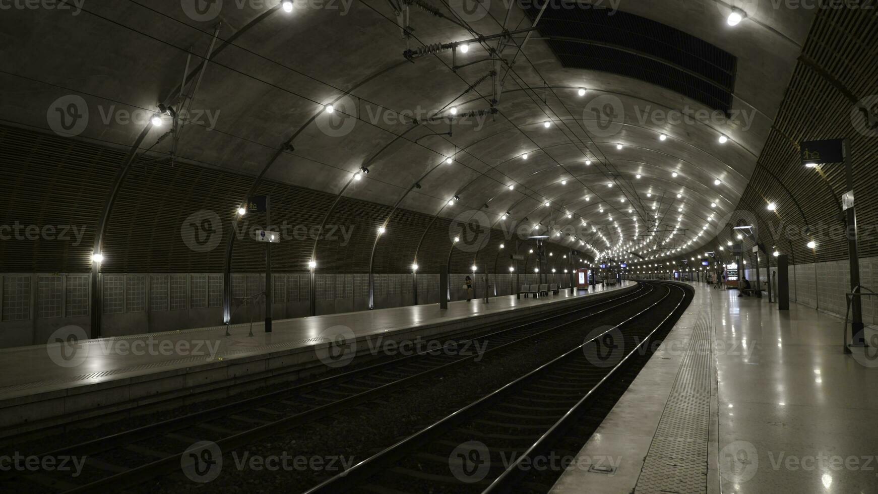underjordisk tunnelbana tunnel med ljus belysning. handling. enkel sten interiör av underjordisk metro med ljus belysning på spår foto