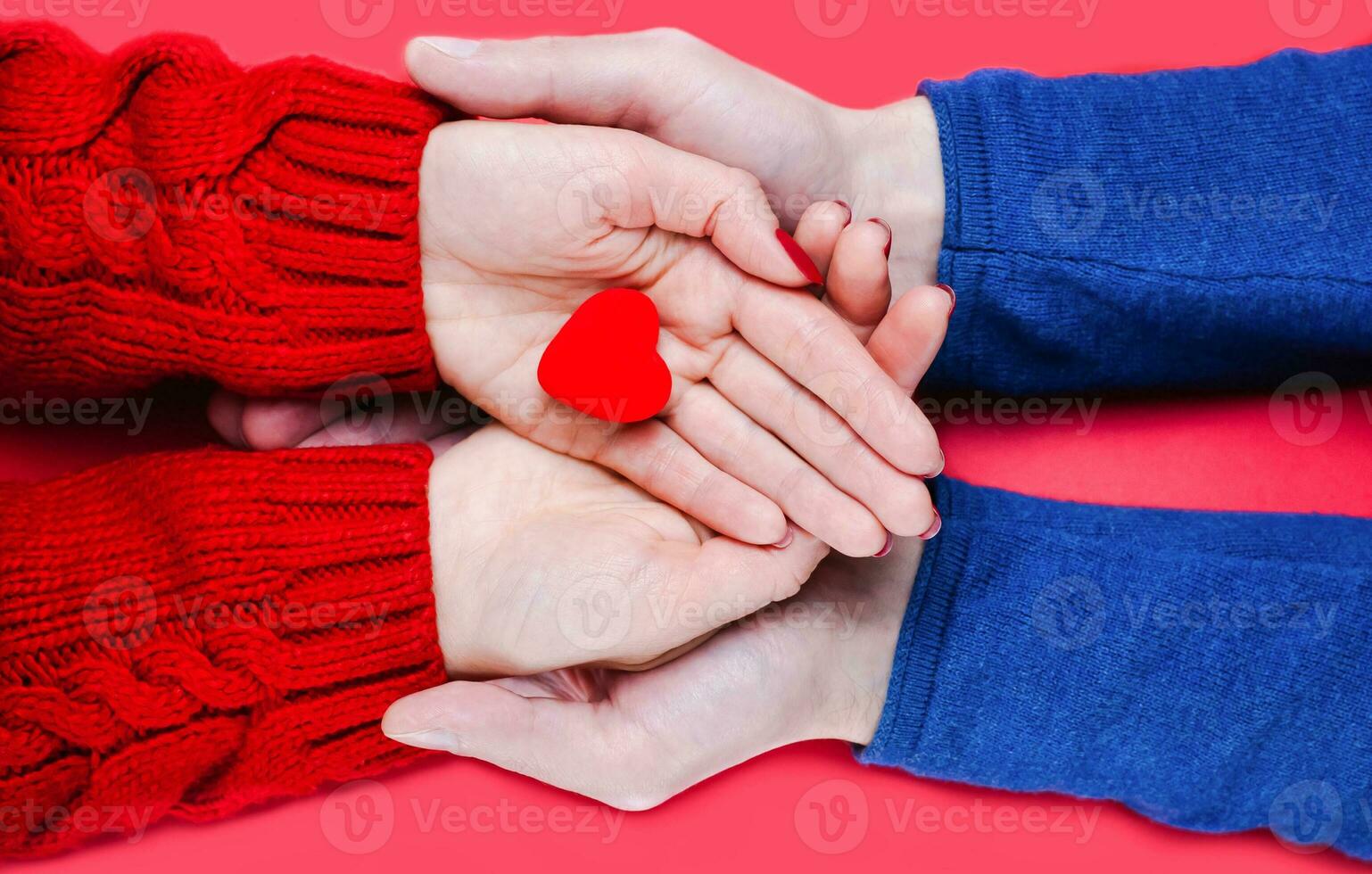 honor och män händer innehar röd hjärta på röd bakgrund. närbild. topp se. foto