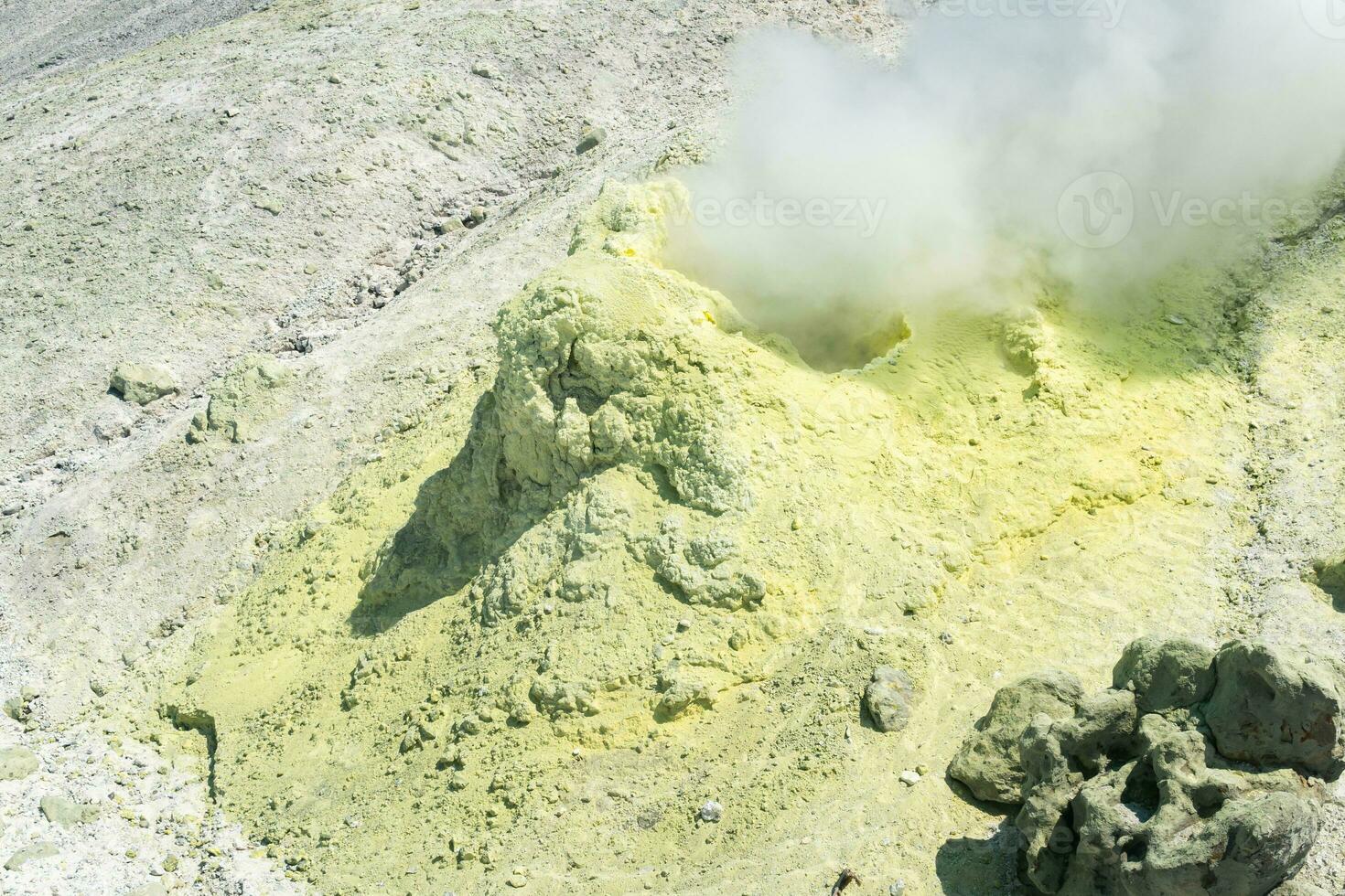 gul kon av kristalliserade svavel runt om en rökning solfatara på de backe av en vulkan foto