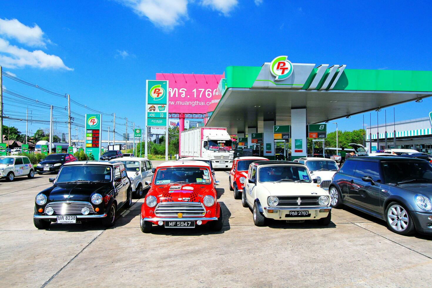 Nakhon Ratchasima, thailand-december 6, 2023 gammal färgrik austin mini tunnbindare bil parkering i gas station och klar blå himmel med kopia Plats. transport, klassisk eller årgång bil och fordon begrepp. foto
