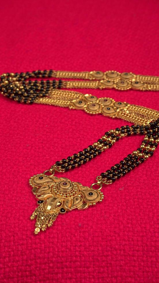 mangalsutra eller gyllene halsband att bära av en gift hinduisk kvinna, arrangerad med vackra backgrond. indiska traditionella smycken. foto