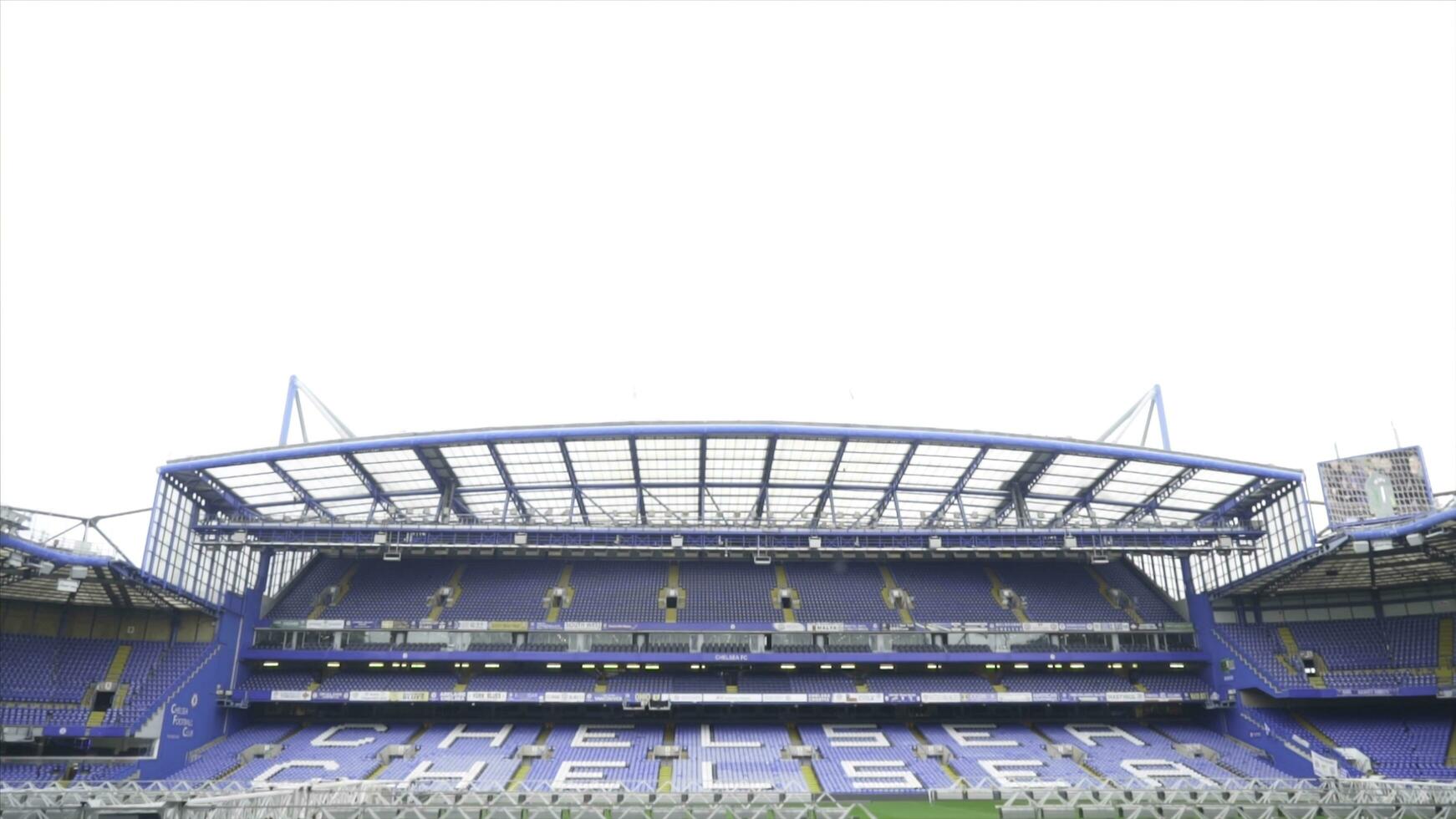 london, Storbritannien-september, 2019. öppen tömma läktaren av fotboll stadion. handling. tömma står med namn av Chelsea fotboll klubb och grön fält med gräsmatta vård Utrustning foto