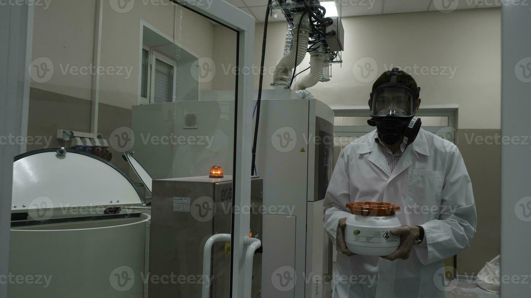 forskare bär skyddande kostym och bärande en burk av toxisk flytande inuti en biohazard område foto