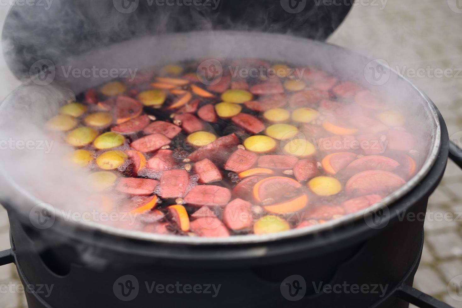 kocken förbereder och häller varm glögg foto