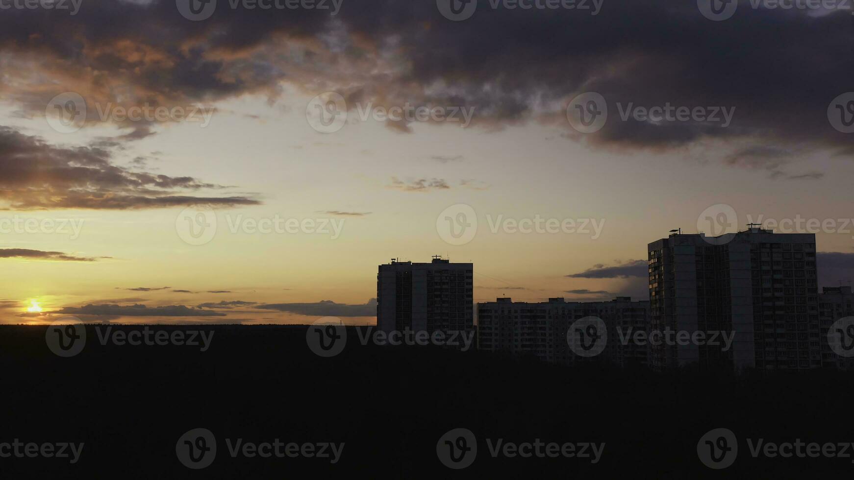 tid upphöra effekt för Fantastisk moln och solnedgång i de himmel ovan de hus. handling. modern urban arkitektur, bostads- hög stiga byggnader belägen i de sovande område av de stad med höst foto