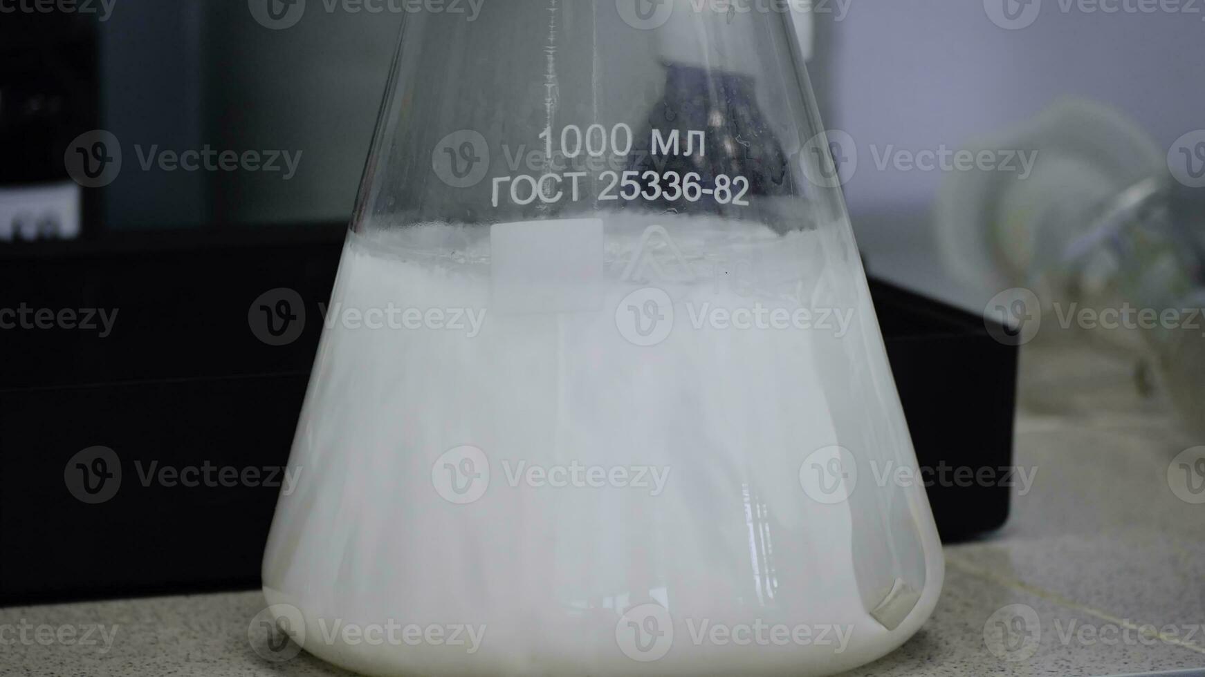 laboratorium glas erlenmeyer konisk flaska fylld med kemisk vit flytande för en kemi experimentera i en vetenskap forskning labb foto