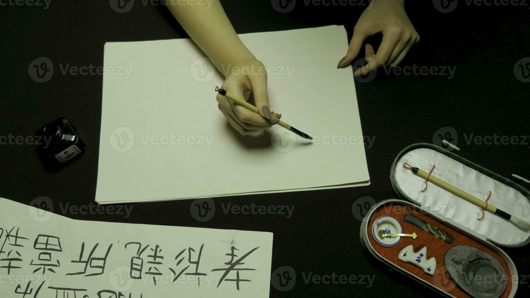 kvinnas hand skrivning kinesisk kalligrafi. kvinna hand innehav en skrivning borsta kinesisk tecken foto