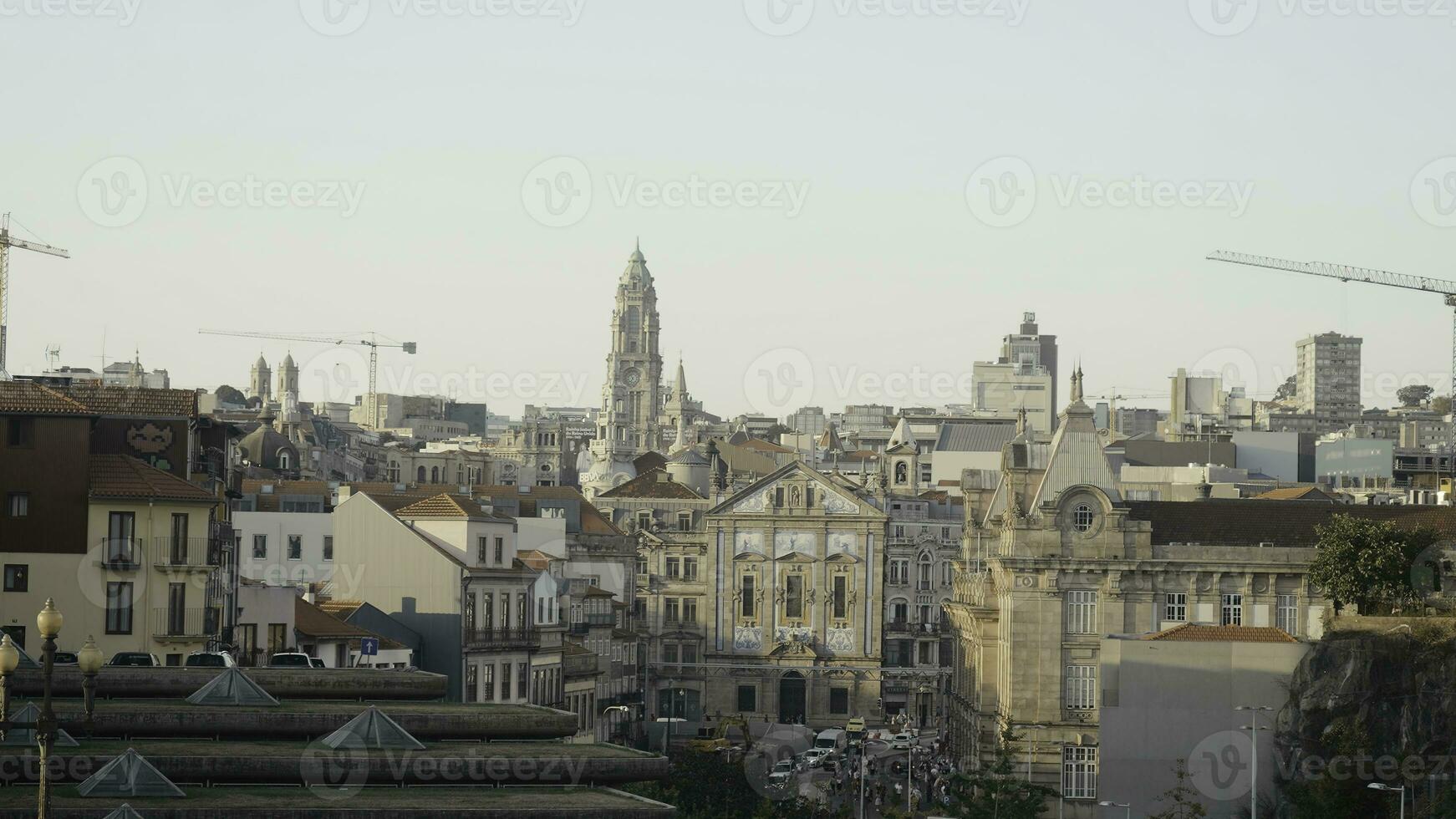 panorama av gammal europeisk stad med konstruktion kranar. handling. gammal torn och byggnader i europeisk stad i morgon- Sol. skön gammal stad med torn och modern konstruktion kranar foto