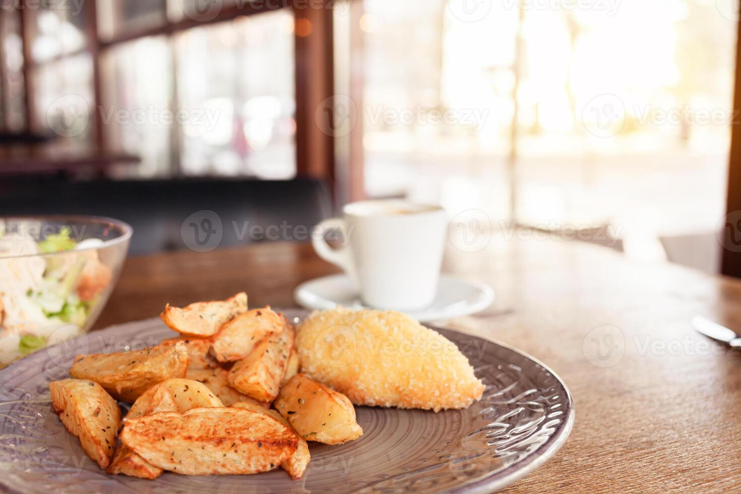 frukost, middag, lunch i en restaurang, Kafé. bakad potatisar med köttbullar, caesar sallad, kaffe americano. intervier, utsökt mat, stor fönster, naturlig solljus. suddig bakgrund foto