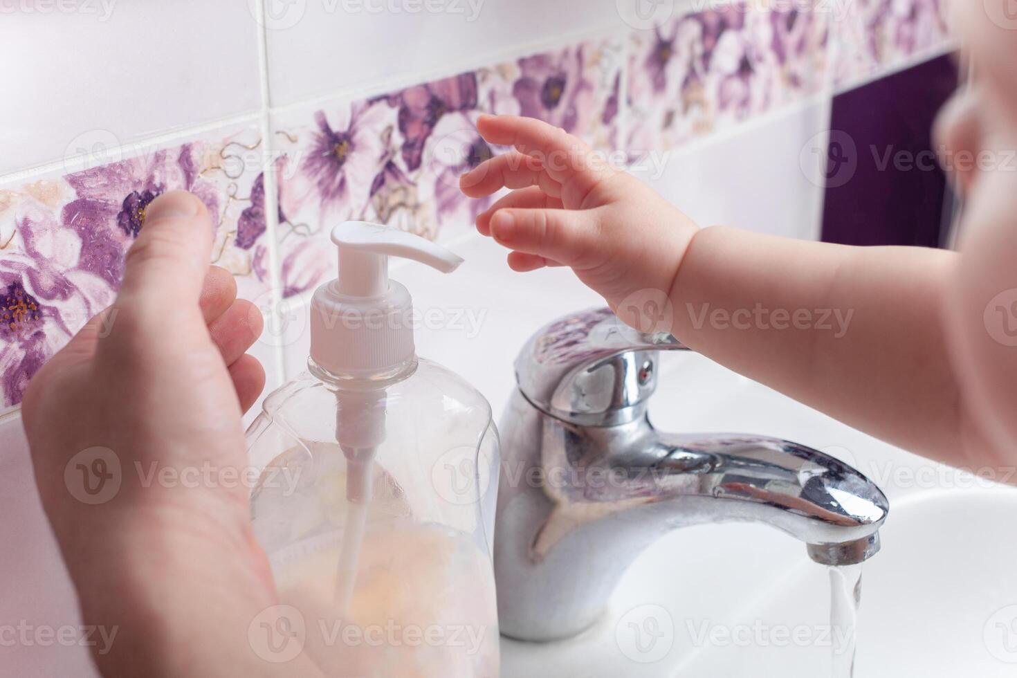 barn tvättar händer i handfat. jet av vatten från knacka. desinfektion av händer med vatten. foto