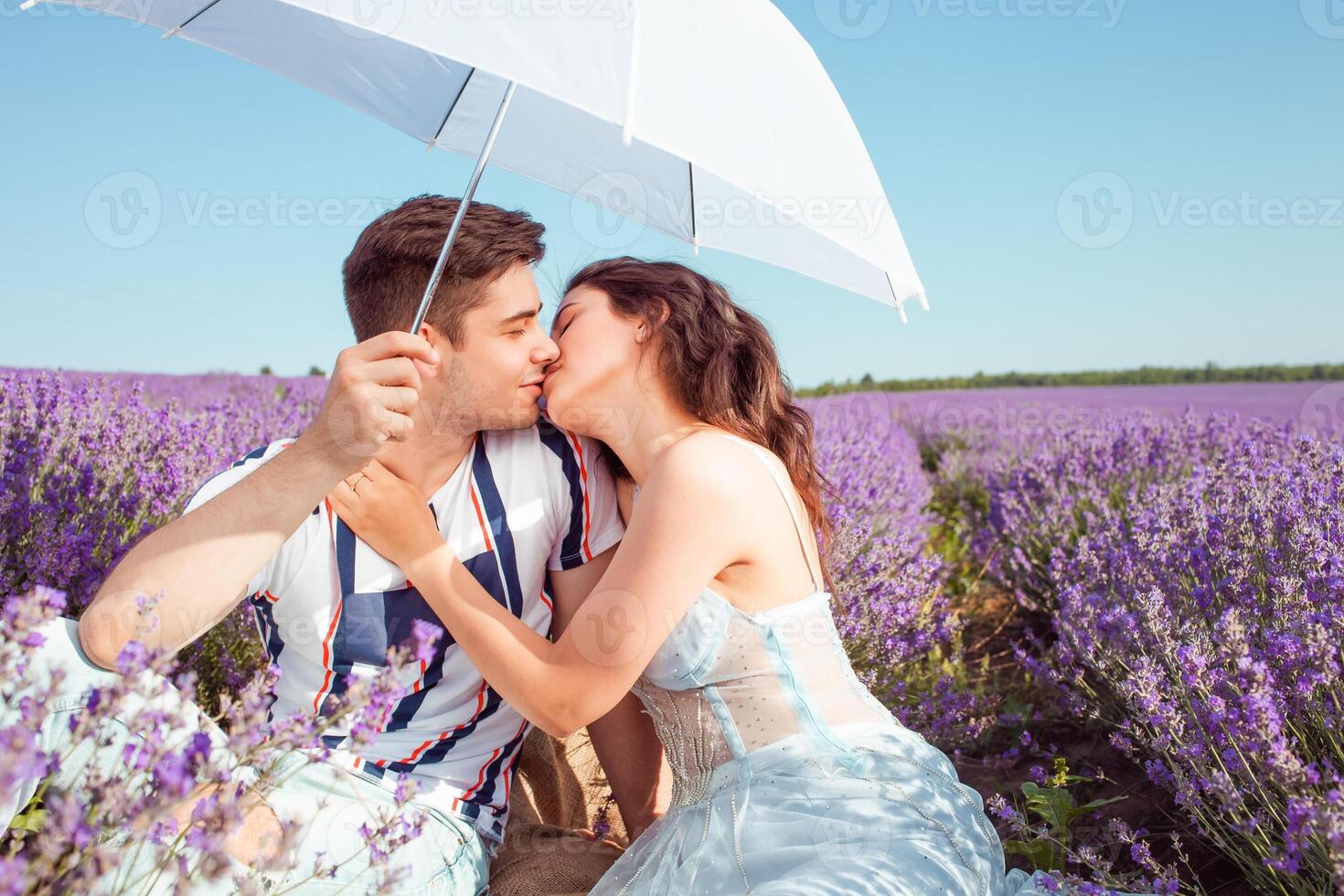 en par i kärlek under en vit paraply på en lavendel- fält kärlek foto