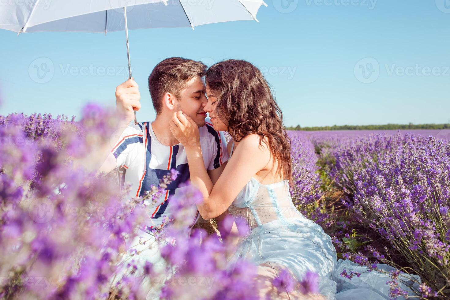 en par i kärlek under en vit paraply på en lavendel- fält kärlek foto