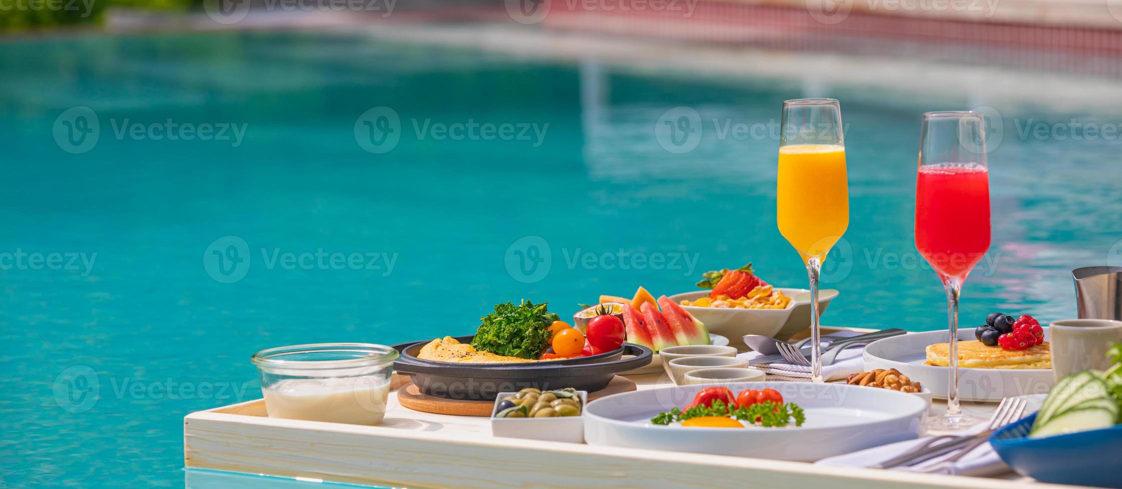 frukost i poolen, flytande frukost i lyxig tropisk resort. bord avkopplande på lugnt poolvatten, hälsosam frukost frukt tallrik hotell resort pool. tropiskt par strand lyx livsstil foto