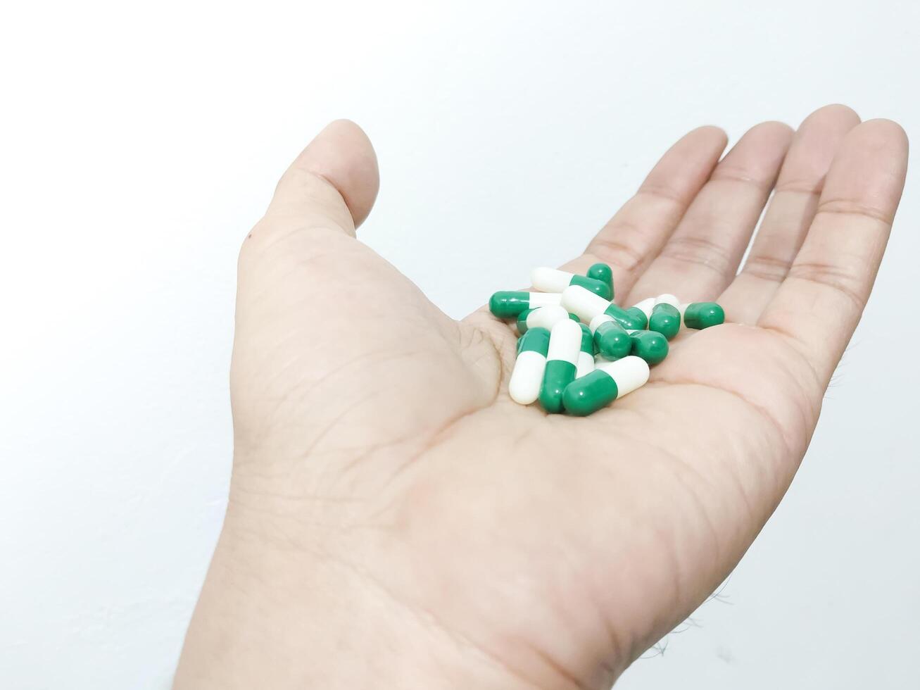 kapsel piller placerad i de handflatan av de hand isolerat på en vit bakgrund foto