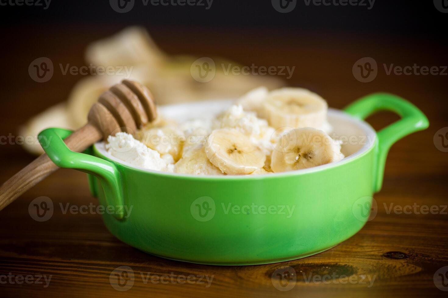 hemlagad stuga ost i en skål med bananer och honung foto