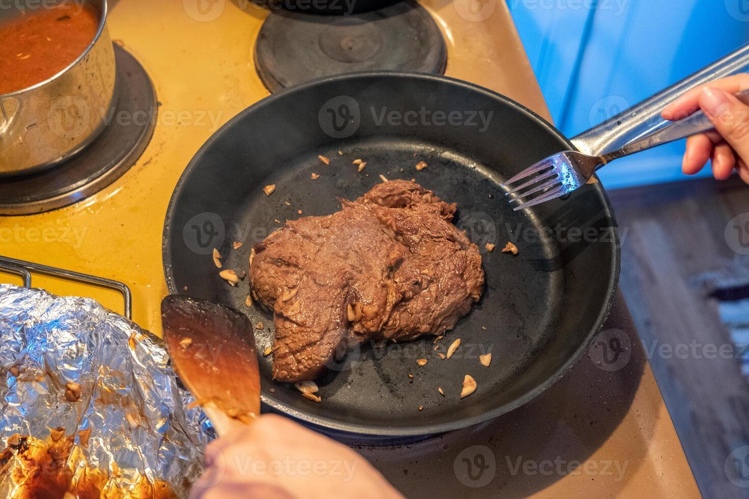 kock fräsning nötkött biff med vitlök på stekpanna foto