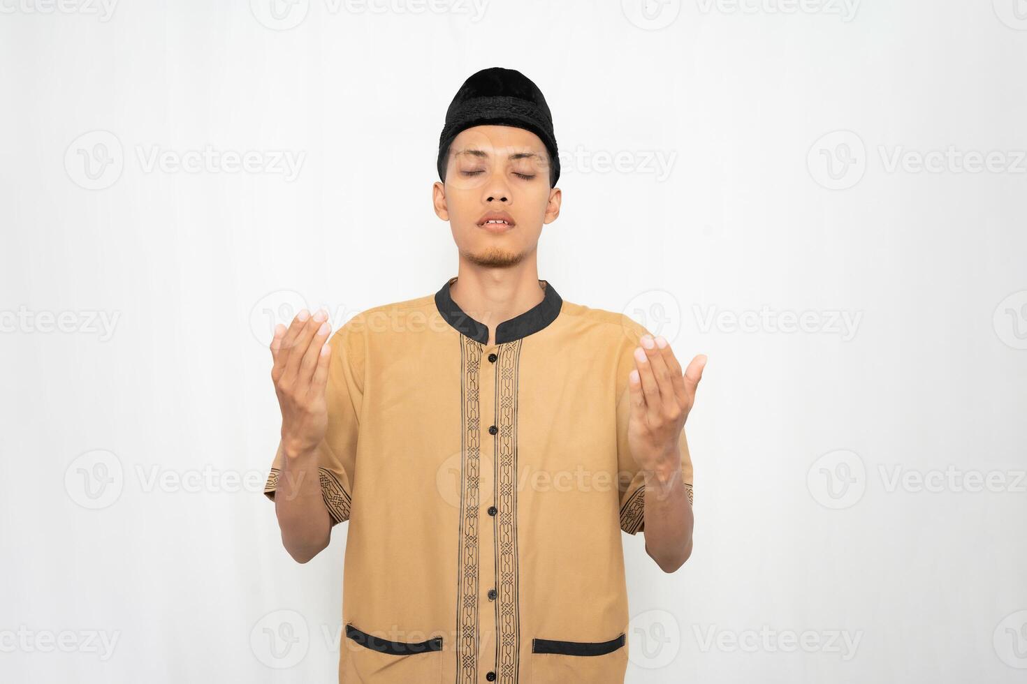 asiatisk muslim man bär muslim kläder är bön- eller lugnande hans hjärta. isolerat vit bakgrund. foto