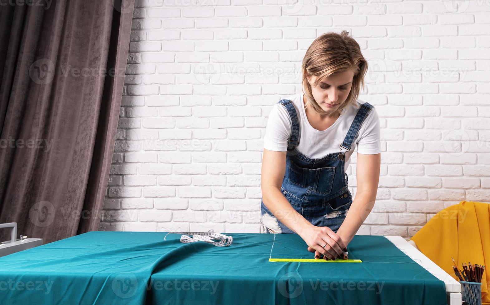 kvinnaskräddare som arbetar med textil i sin studio foto