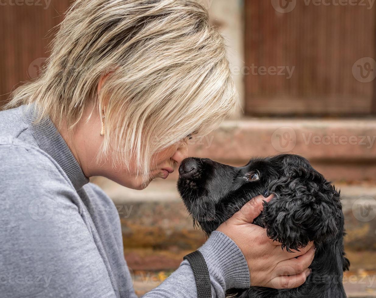 ung blond kvinna vidrör hennes hundnos utanför foto