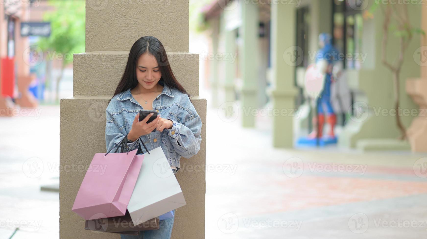 asiatiska kvinnliga shoppare använder en smartphone för att söka efter produktinformation. foto