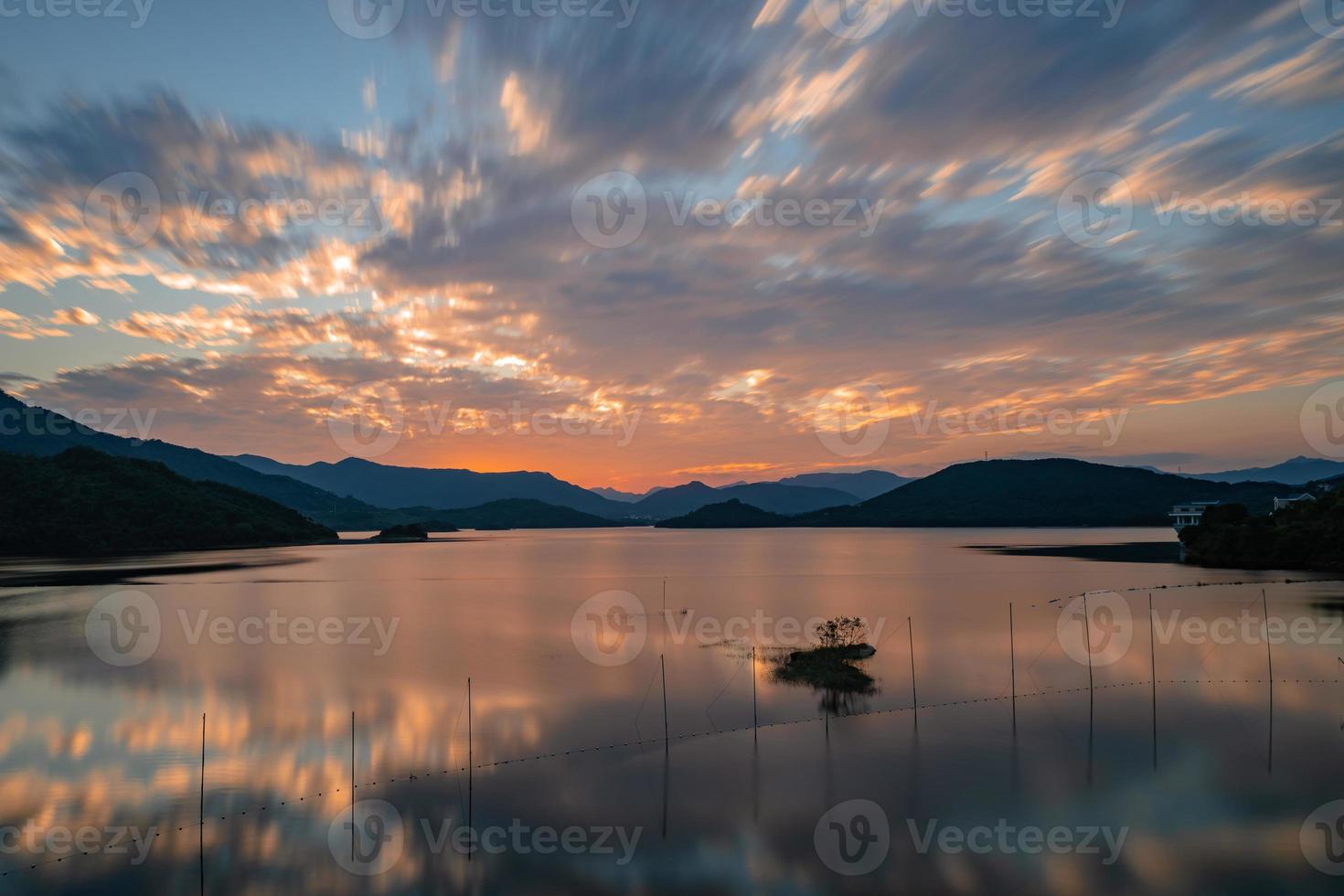 kvällssjön speglade solnedgången och bergen foto