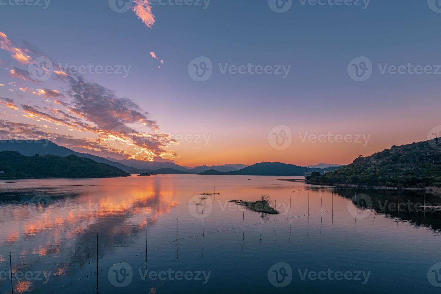 kvällssjön speglade solnedgången och bergen foto