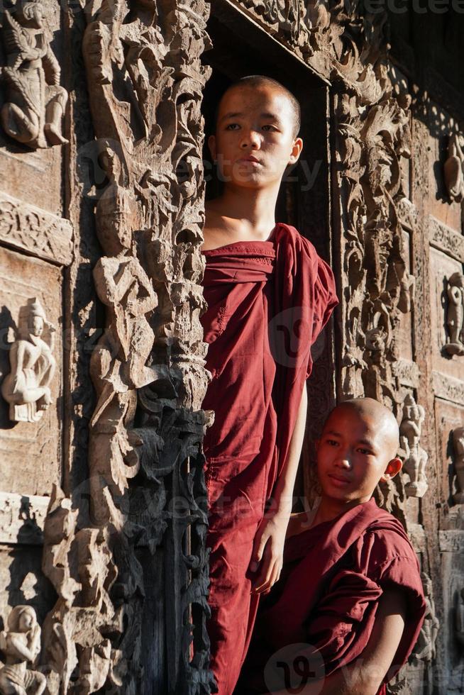 porträtt av grupp asiatisk nybörjarmunk i stående vid dörren till templet foto