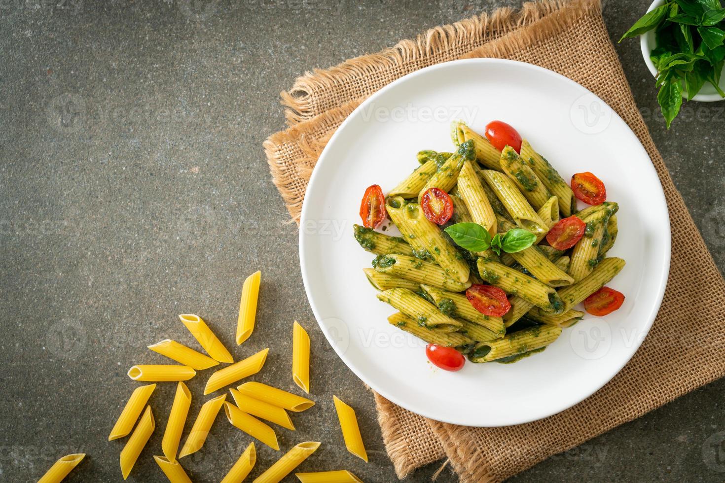 penne pasta med pestosås och tomater foto