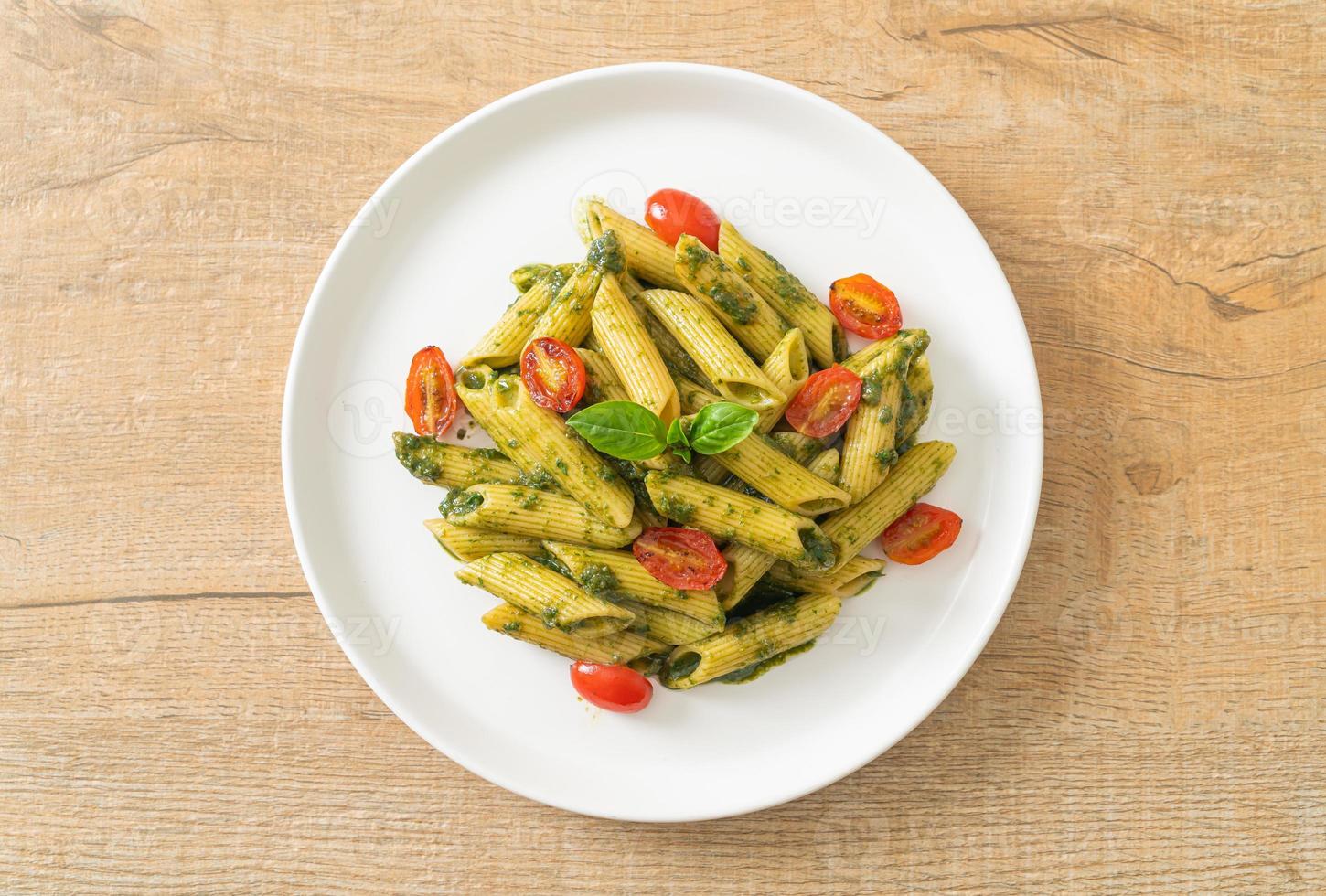 penne pasta med pestosås och tomater foto