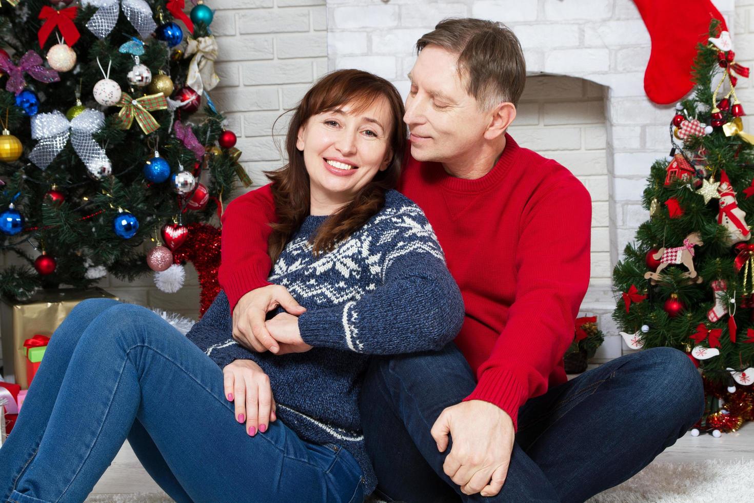 lyckligt medelålders par i juleldplats i hemmet, nyårsfirande foto