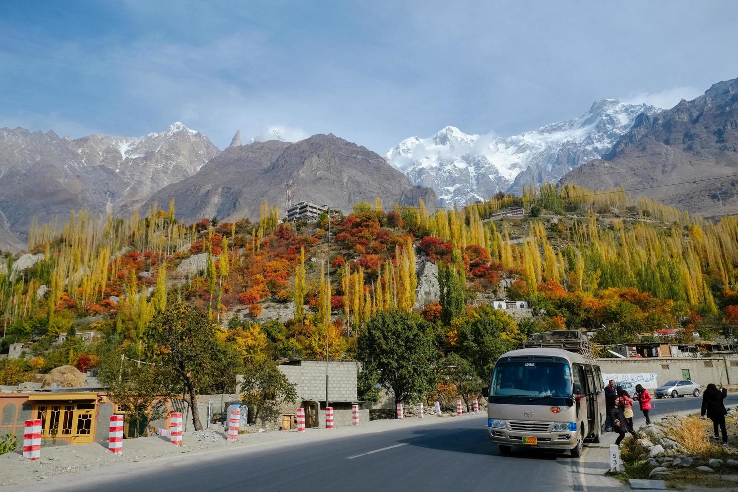 hunza valley, pakistan, 2017 - turism i gilgit baltistan under höstsäsongen. färgglada lövskogsträd mot snötäckta bergstoppar i karakoramområdet. foto