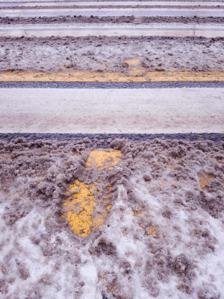 smutsig snö med fotavtryck på övergångsstället. foto