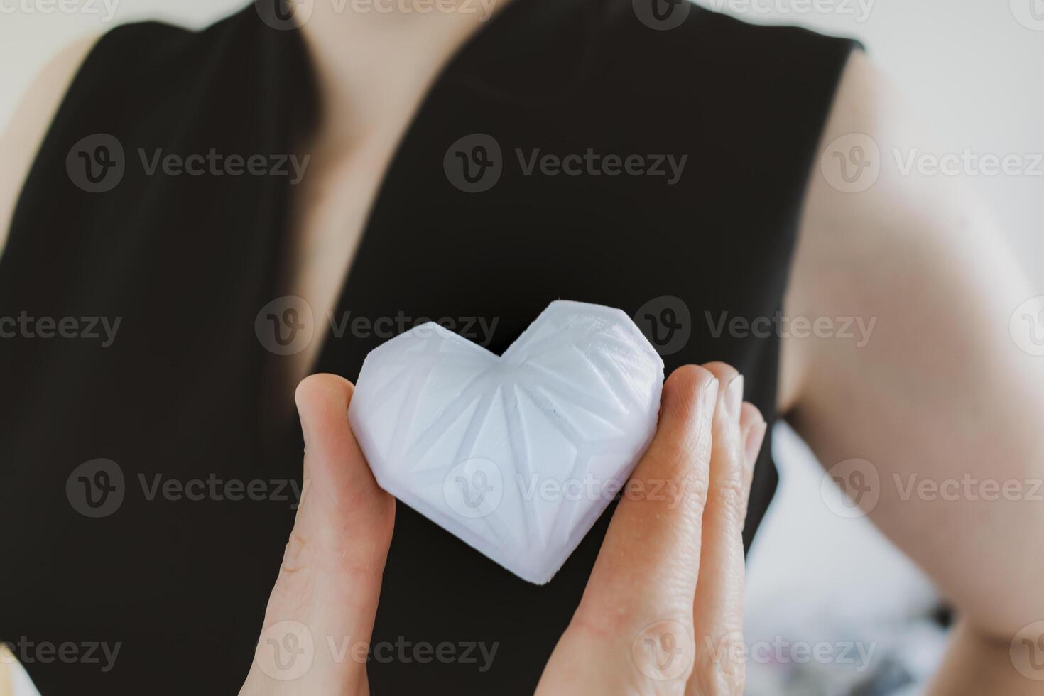 kvinna innehav vit 3d tryckt hjärta. idealisk för olika begrepp, kärlek och hälsa, tacksamhet och välgörenhet antingen teknologi foto