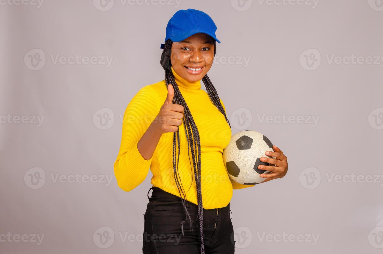 ung fotboll innehav boll och gjorde tummen upp foto