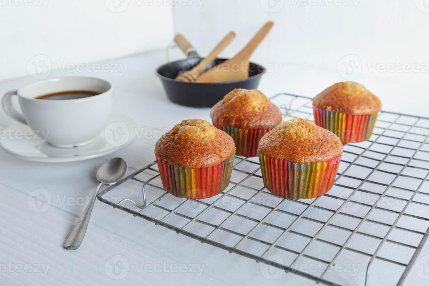 hemgjorda muffins och kaffekopp på vitt bord foto