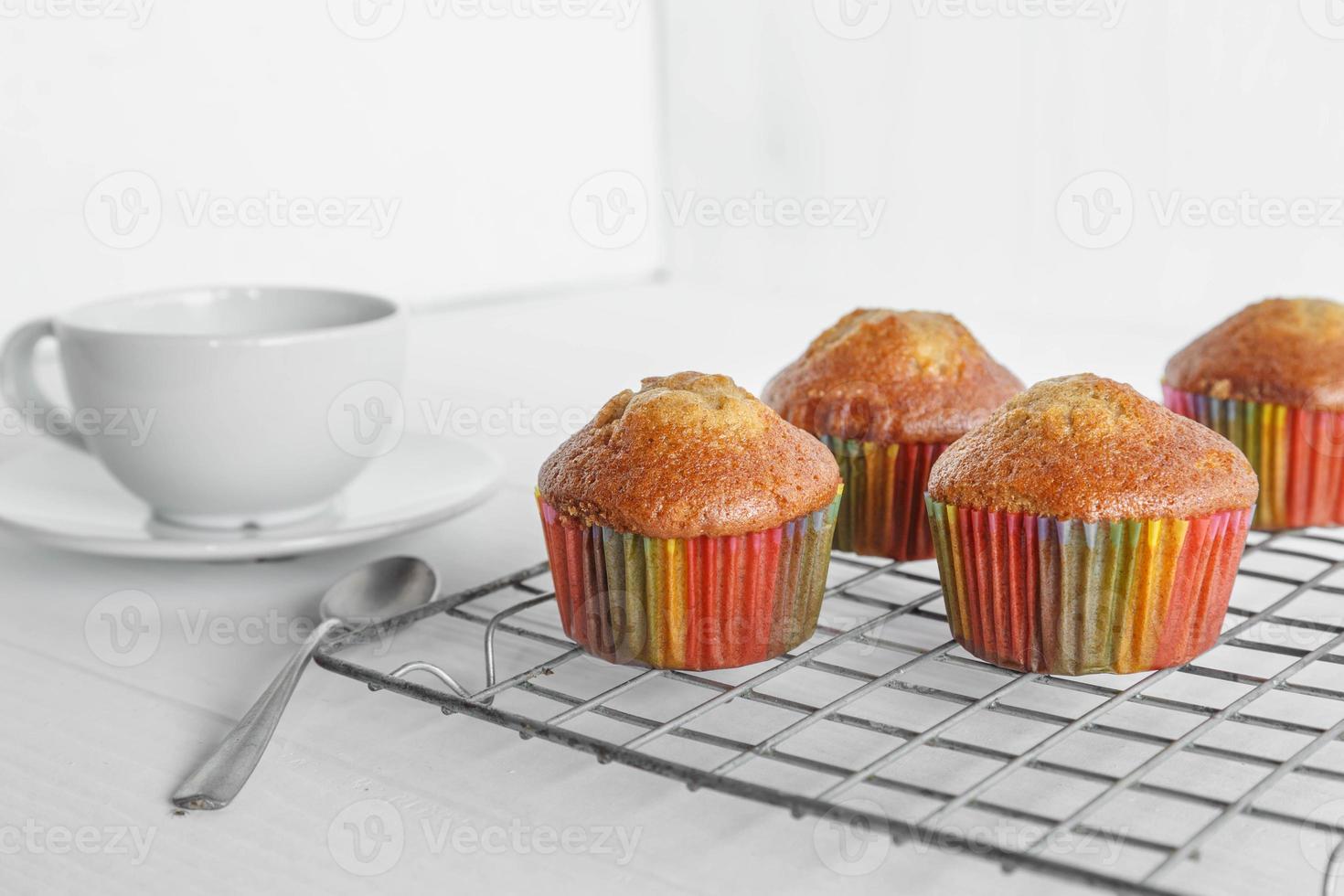 hemgjorda muffins och kaffekopp på vitt bord foto