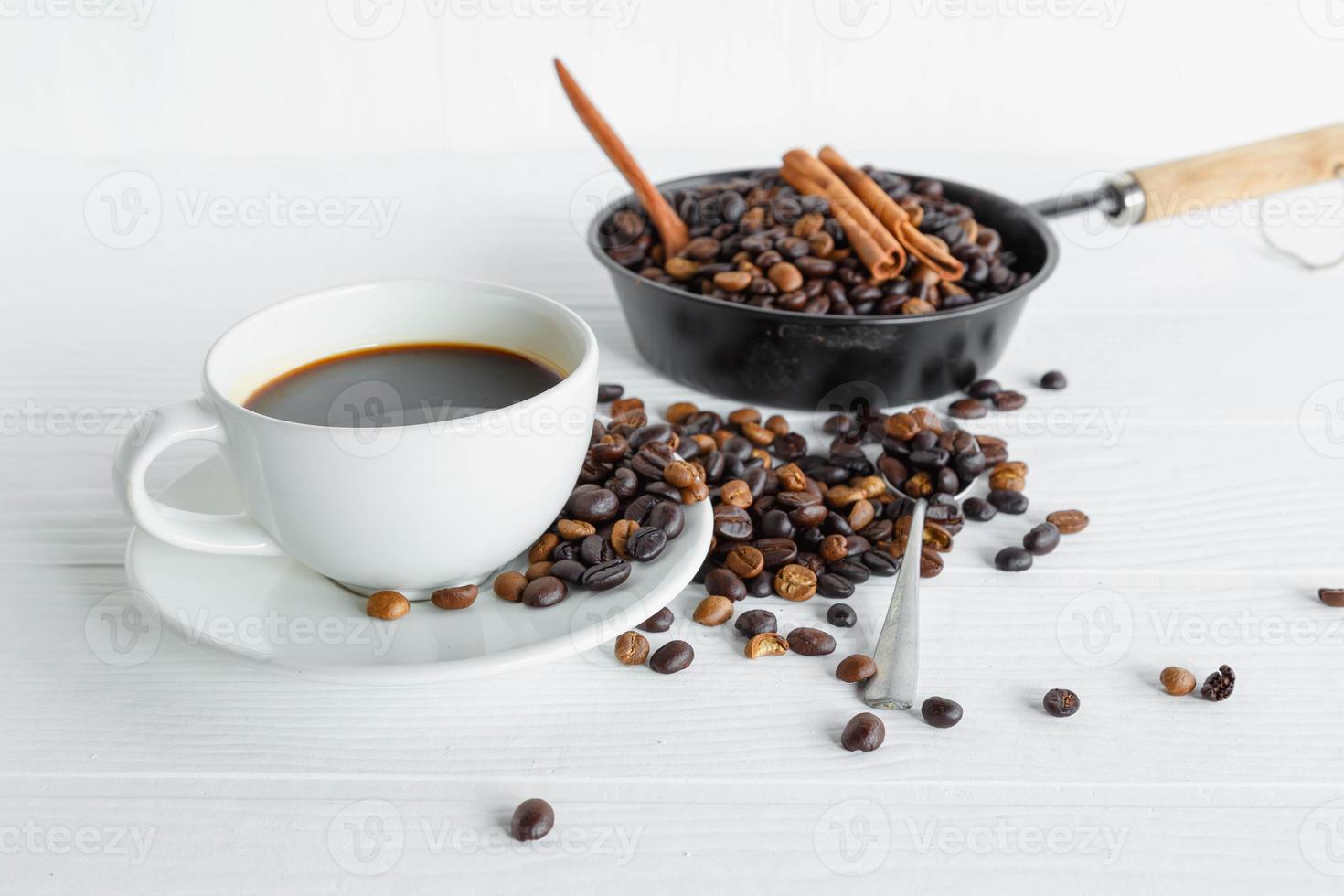 kaffekopp och kaffeböna på vitt träbord foto