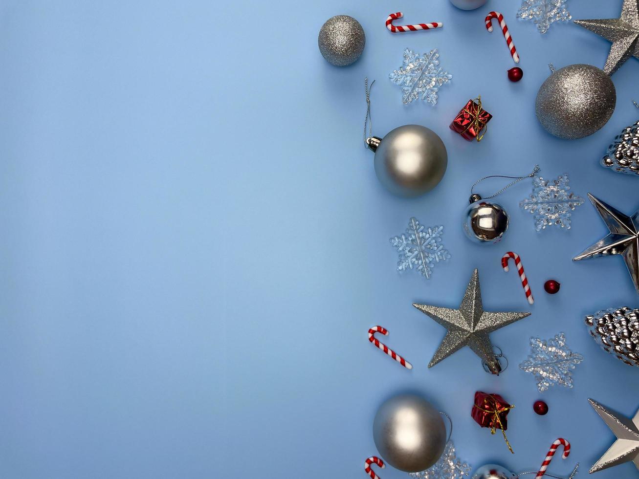 juldekorationer, glänsande stjärnor, silver- och guldbollar, snöflingor på blå bakgrund foto