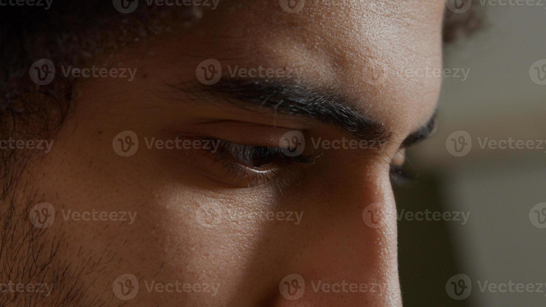 extrem närbild av ansiktet på ung Mellanöstern man, ser fokuserad, fingrar röra skägg foto