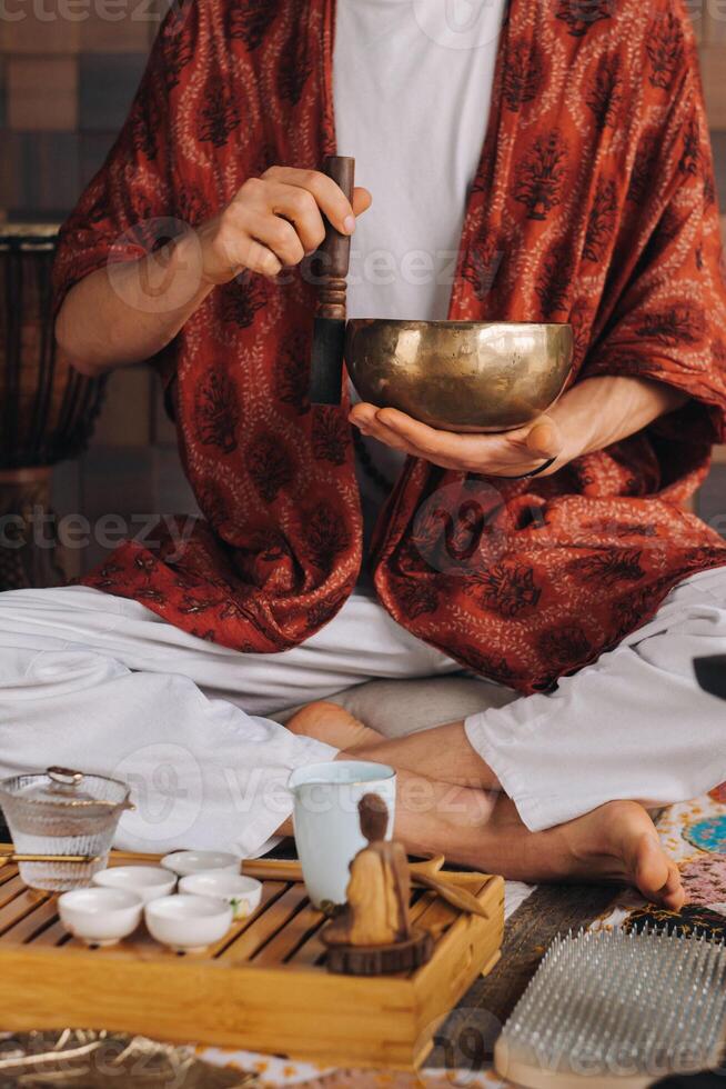 tibetan sång skål i de händer av en man under en te ceremoni foto