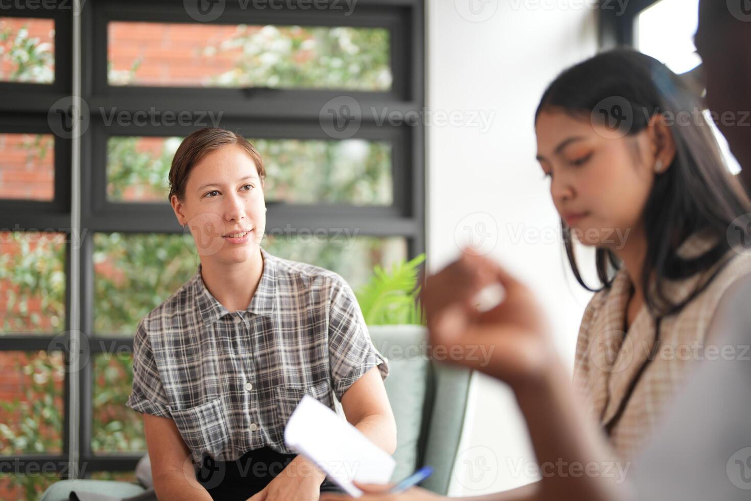 olika anställda samlade in i kontor har roligt under brainstorming medan diskuterar ny idéer projekt. raser medarbetare möte på coworking Plats område. team av ung människor i kontor. foto