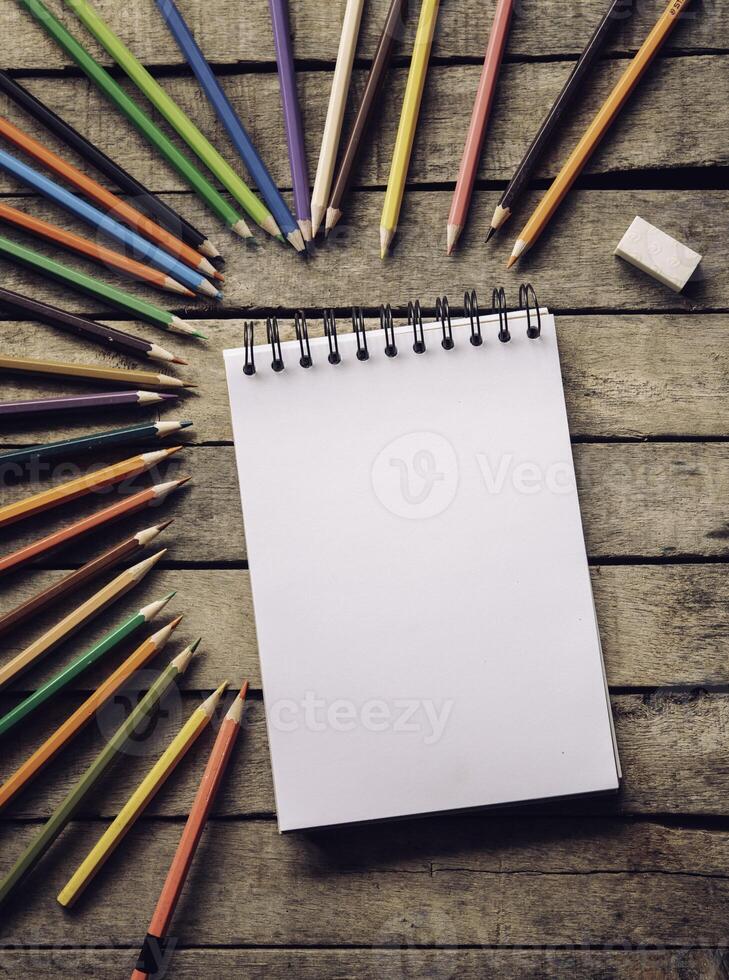 Färg penna och skissbok på trä bakgrund. foto