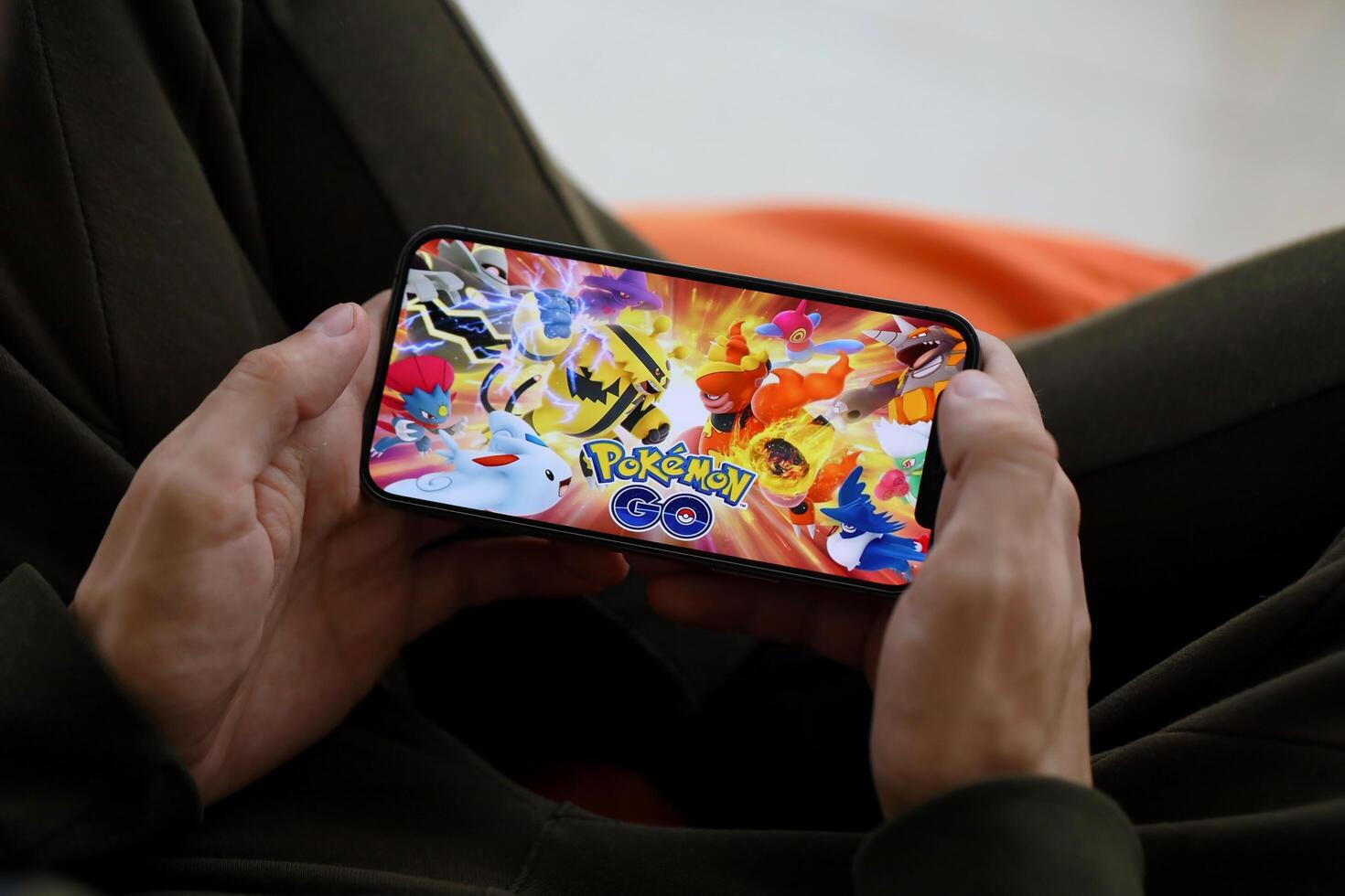 pokemon gå mobil ios spel på iphone 15 smartphone skärm i manlig händer under mobil gameplay foto