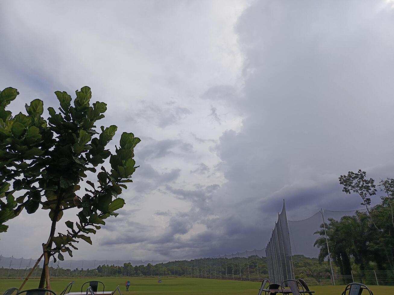 Foto av himmel se och golf kurs med grön gräs
