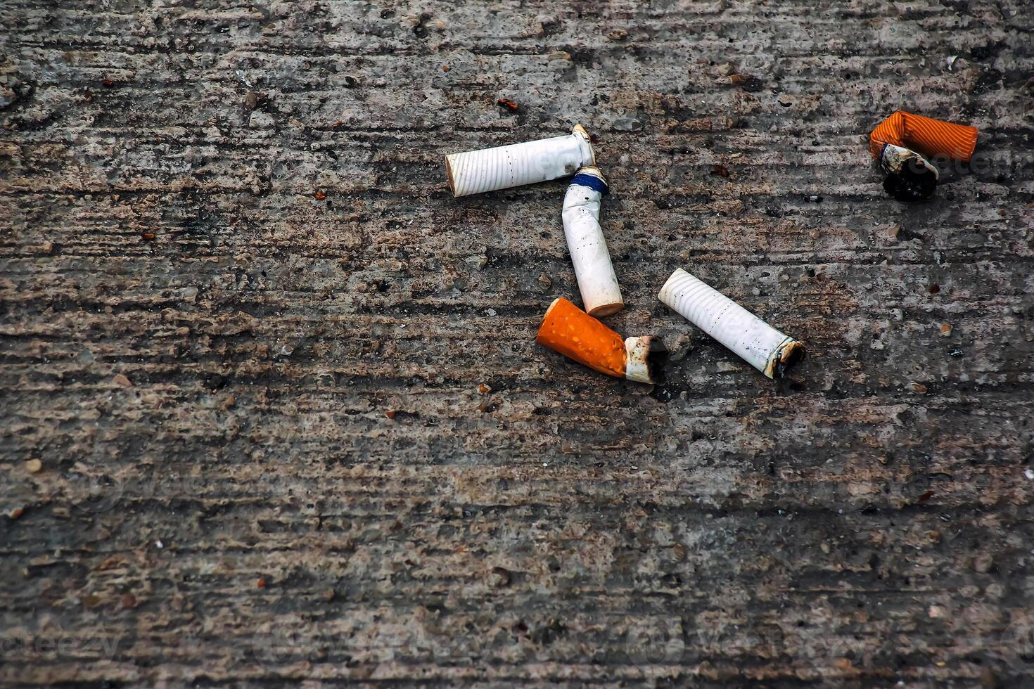 flera cigarett butts är liggande på de golv. anti-rökning begrepp. foto