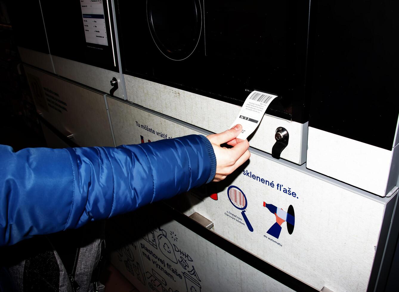 nitra, slovakia - 16.01.2024 närbild av en mannens hand tar emot en kolla upp för returnerad behållare. foto