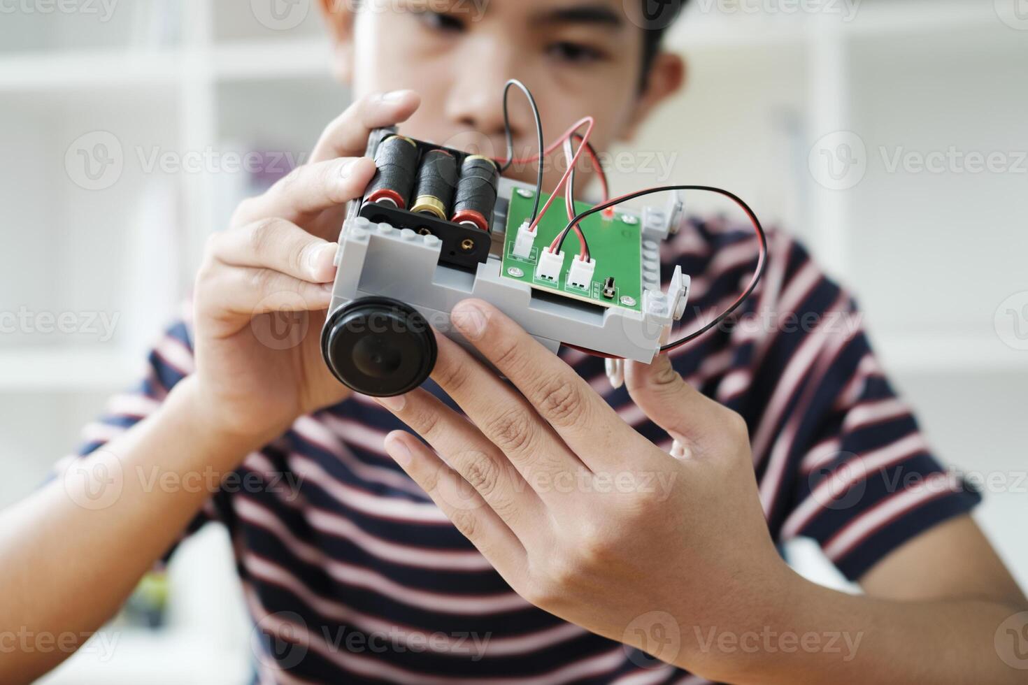 asiatisk tonåring håller på med robot projekt i vetenskap klassrum. teknologi av robotik programmering och stam utbildning begrepp. foto