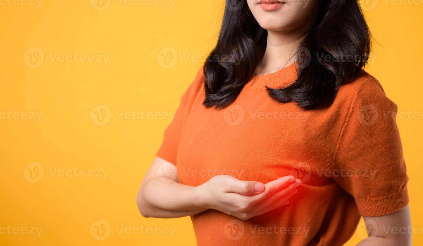 prioritera bröst hälsa på värld hälsa dag, bevittna en kvinnas bröst cancer kolla upp på vibrerande gul bakgrund. foto