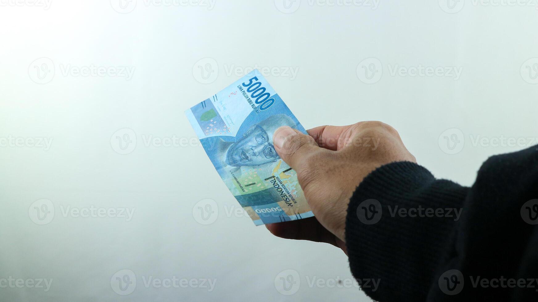 hand håll pengar rupiah, transaktion begrepp, finansiell begrepp foto